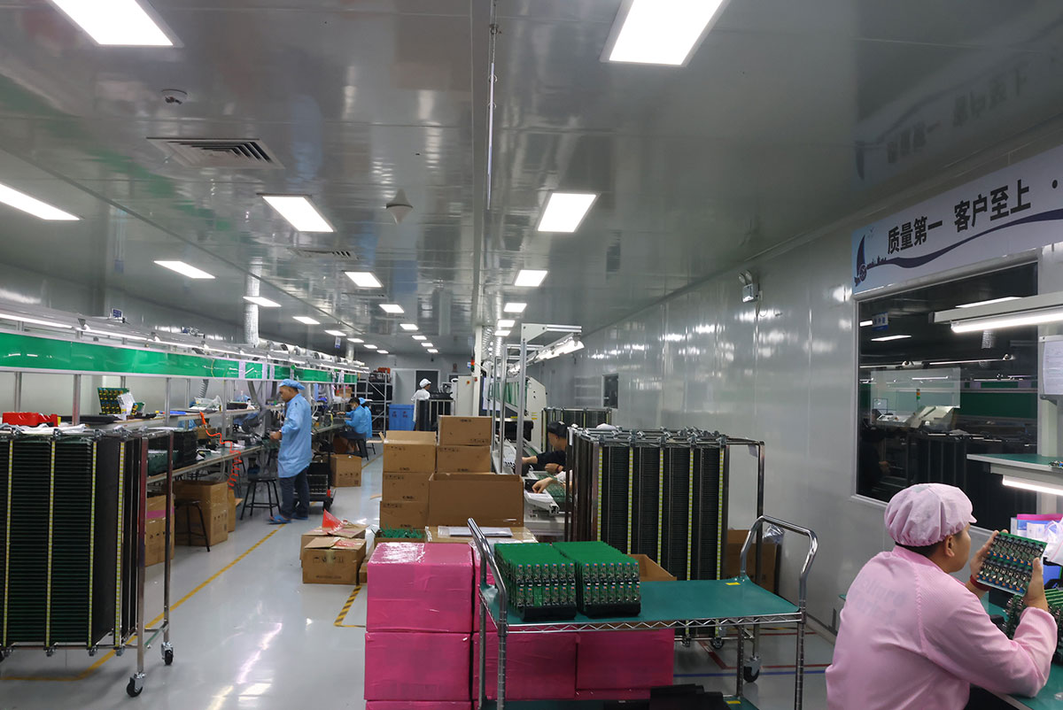 PCB manufacturing workshop with operators inspecting boards at workstations