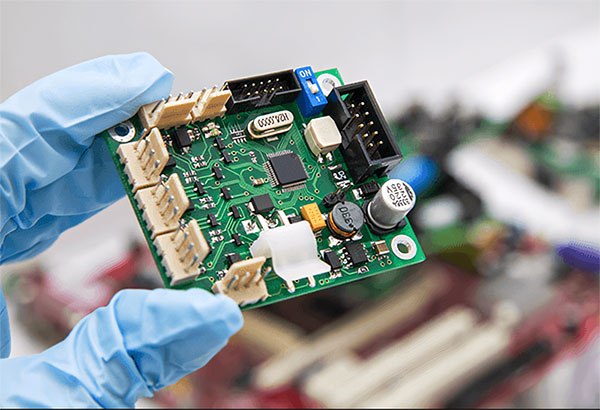 Engineer holding and visually inspecting an assembled medical PCBA prototype