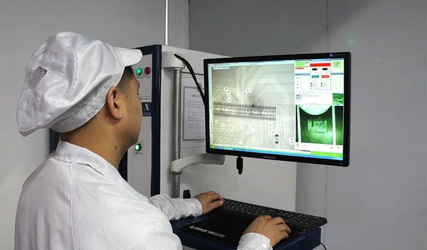 Technician reviewing a PCB assembly X-ray inspection image on a monitor